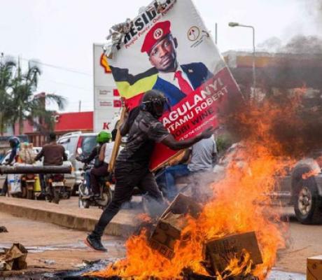 A supporter of Bobi Wine carries his poster as they protest against his arrest PHOTO | AFP