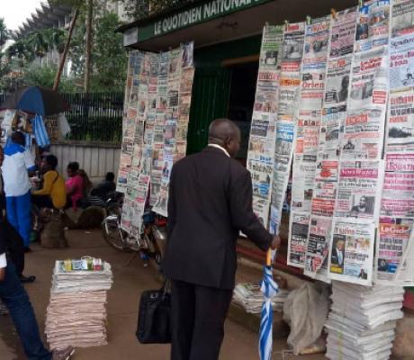 Some Cameroonians reading newspaper front pages at a kiosk adjacent the Ministry of Finance in Yaoun