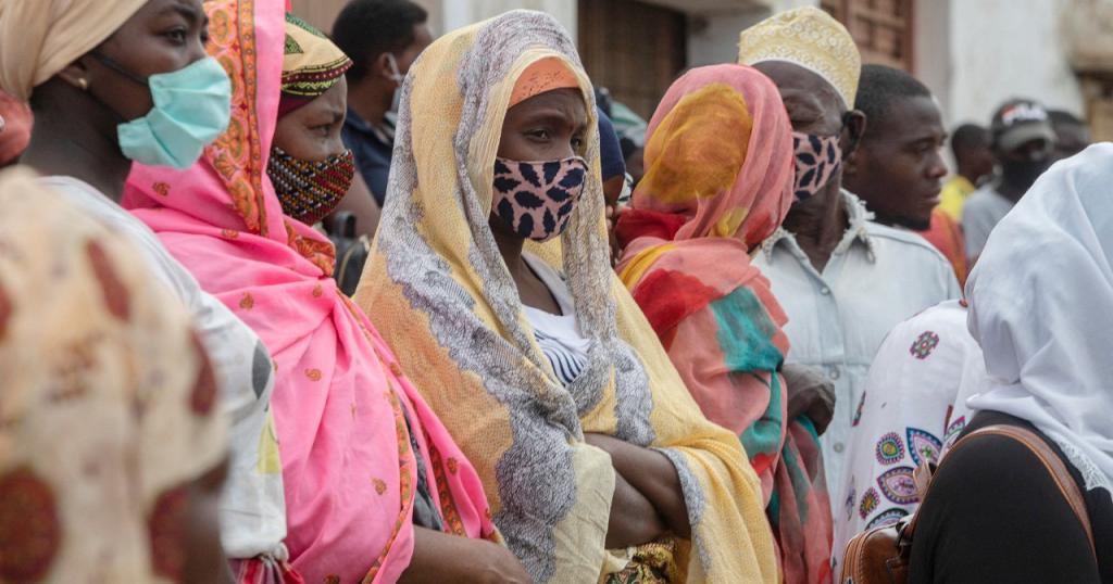 Families wait outside the port of Pemba on April 1, 2021, for the boat of evacuees from the coasts of Palma