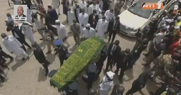 Before Amadou Gon Coulibaly's burial, relatives surrounded his remains and prayed for him