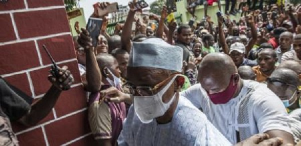 Guinean President Alpha Condé was guided through the crowd during his visit to the police officers