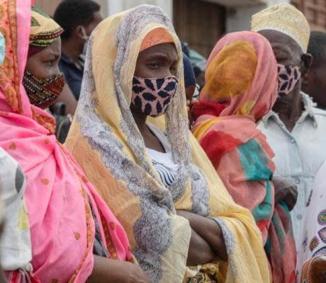 Families wait outside the port of Pemba on April 1, 2021, for the boat of evacuees from the coasts of Palma