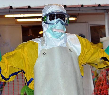 A health worker wearing protective gear is sprayed with disinfectant at the Nongo ebola treatment centre in Conakry, Guinea