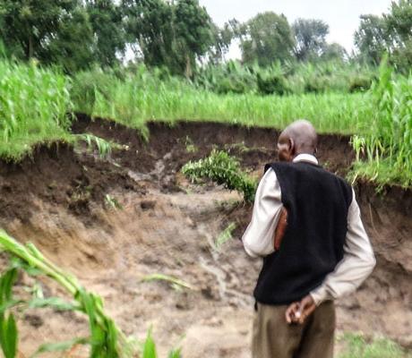 A man stands near a landslide scene in Nabukelema Cell