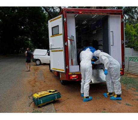 Paramedics put a man with Covid-19 symptoms into an ambulance in Pretoria, South Africa