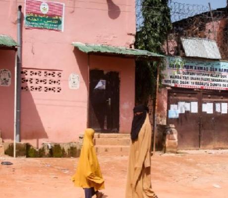 Young girls walk past a boarding school in Kaduna where hundreds of students were rescued in 2019
