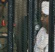 Omar al-Bashir appearing in court in a cage